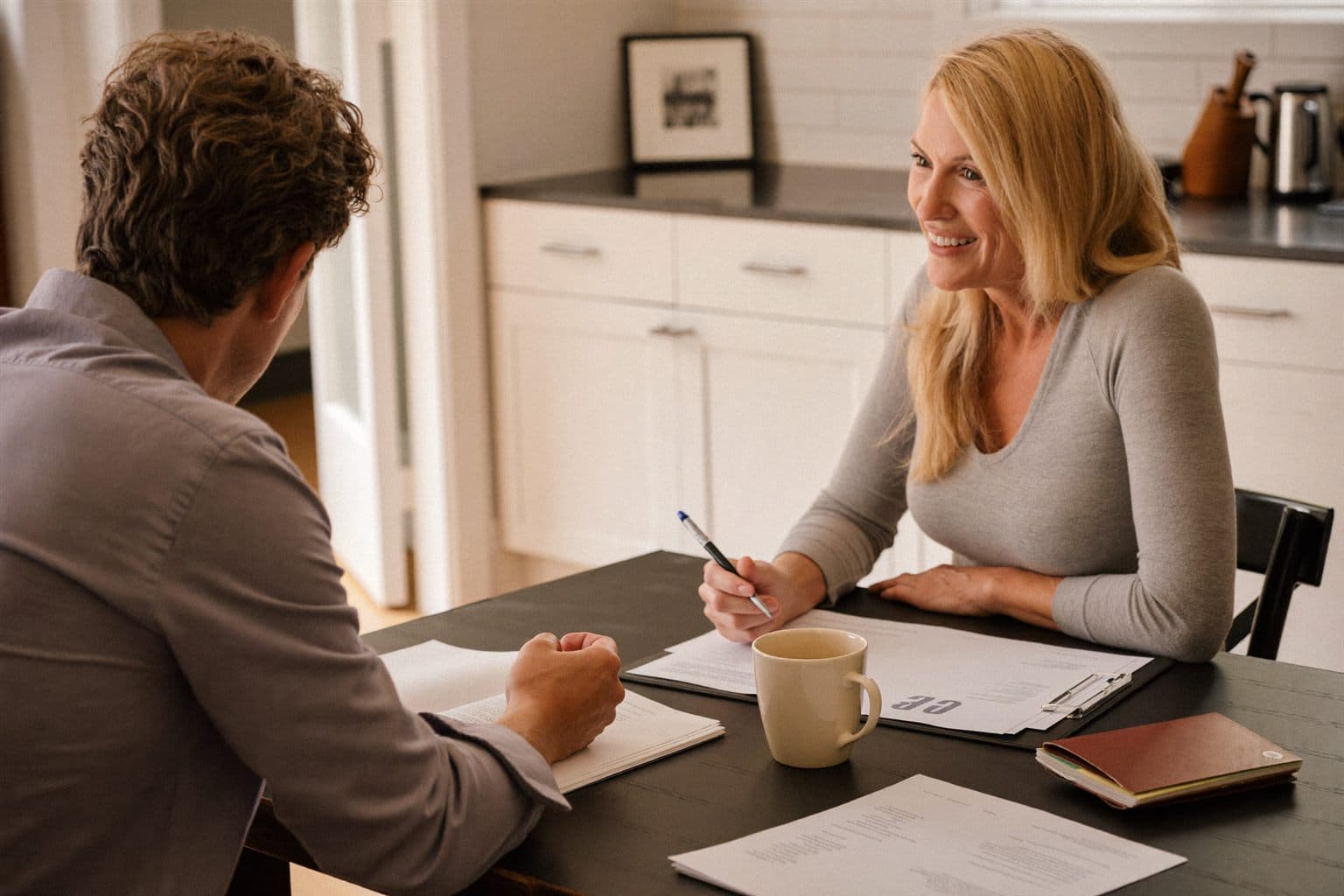 A local buyer walking a homeowner through the offer paperwork at a kitchen table